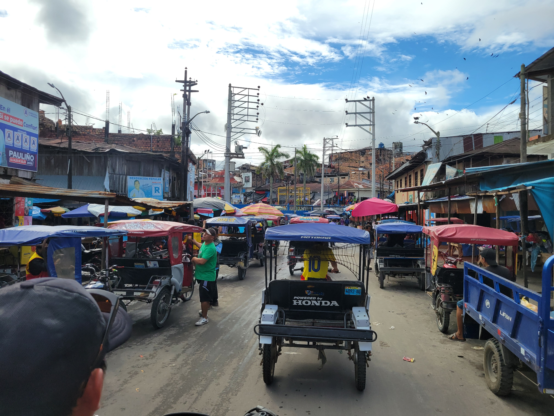 Busy market street in Nauta filled with moto taxis and vendors