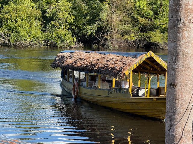 Villagers loading baskets and supplies onto a riverboat