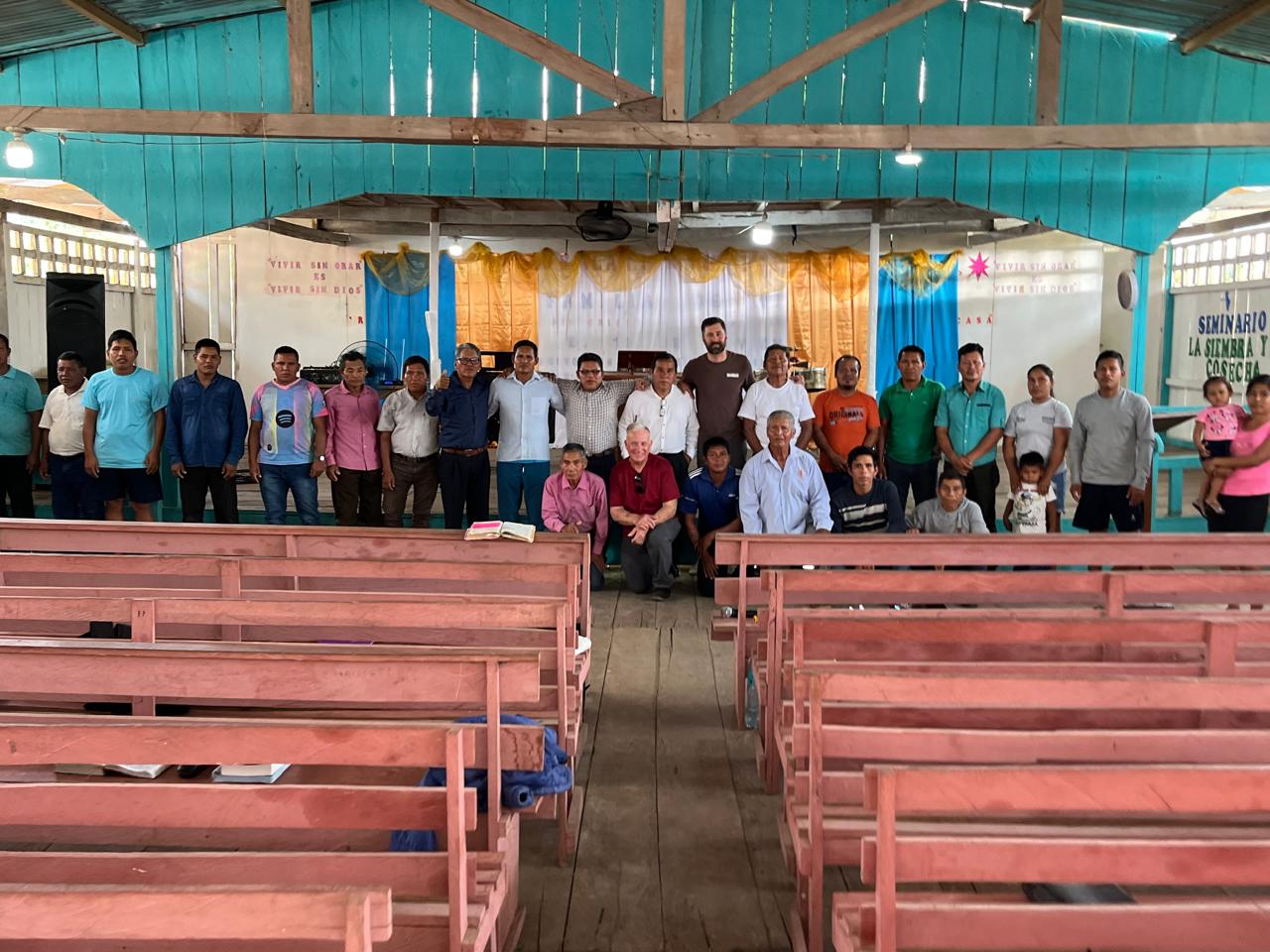 Group photo with seminary students inside a wooden chapel
