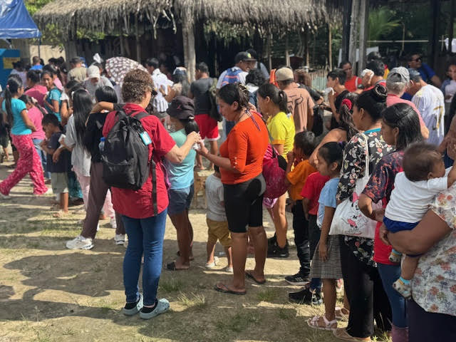 Long line of villagers waiting outside tents at a health clinic