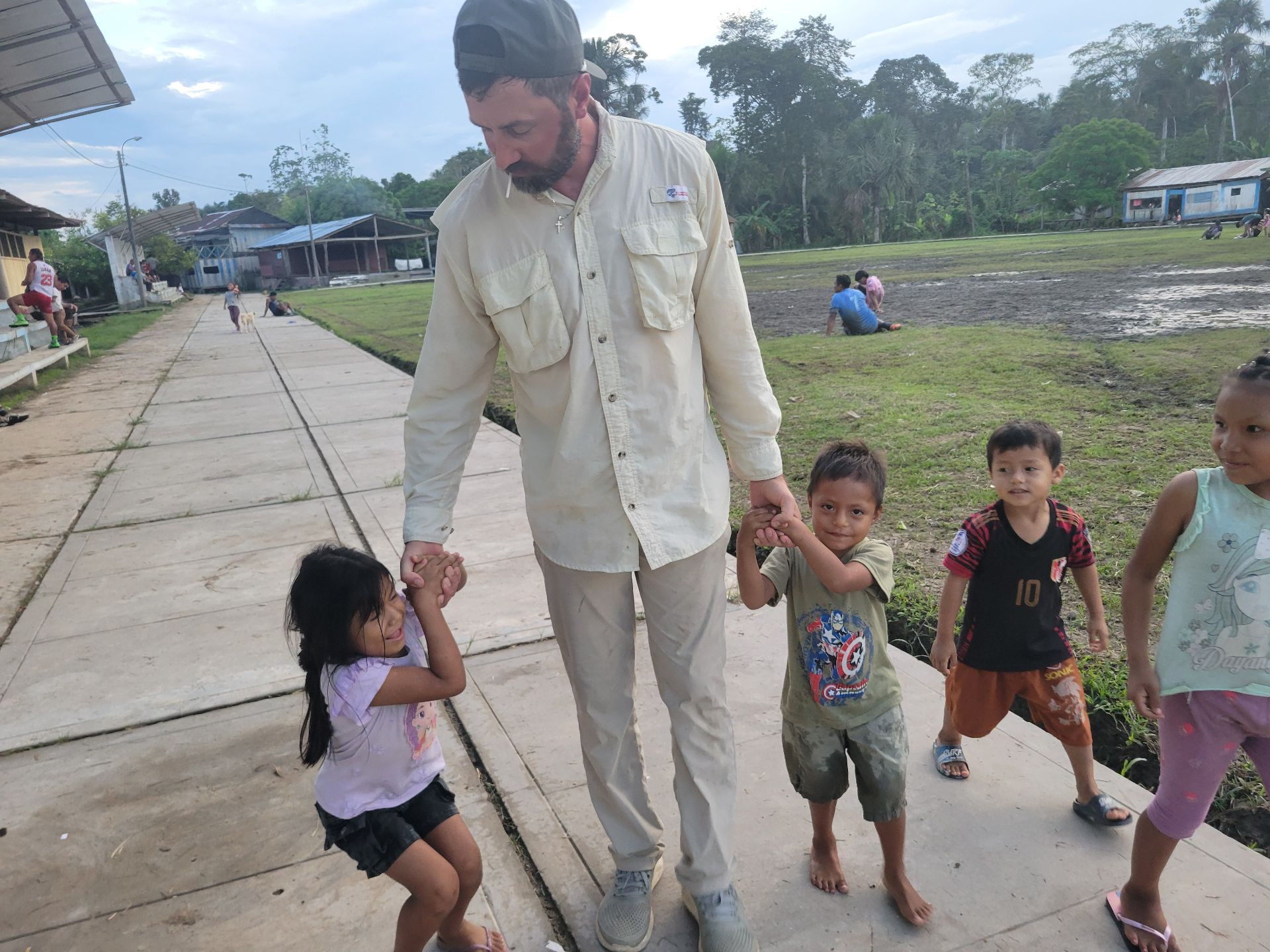 Man holding hands with children on a village path
